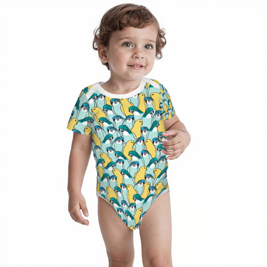 A toddler wearing a short-sleeve bodysuit with a repeating penguin pattern in yellow, teal, and dark blue on a white background.